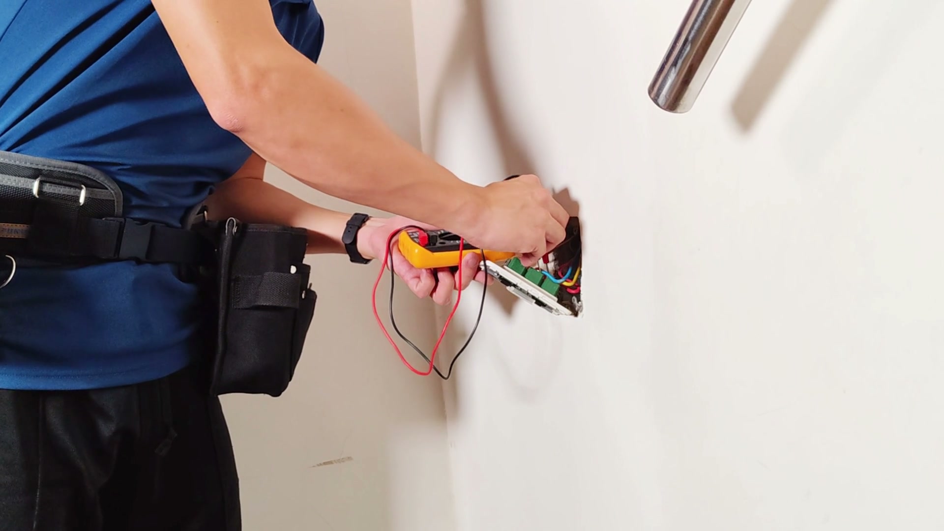 An electrician testing a circuit with a multimeter.